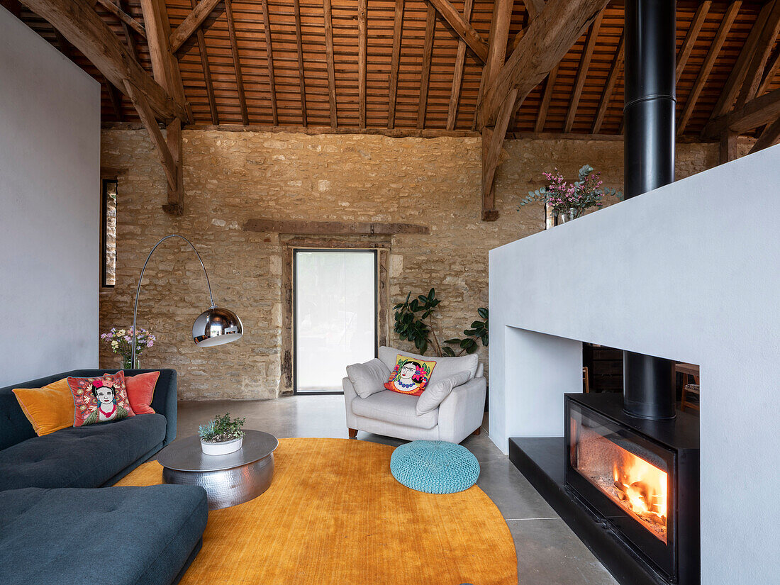View of living room area with large double sided fireplace in a former barn