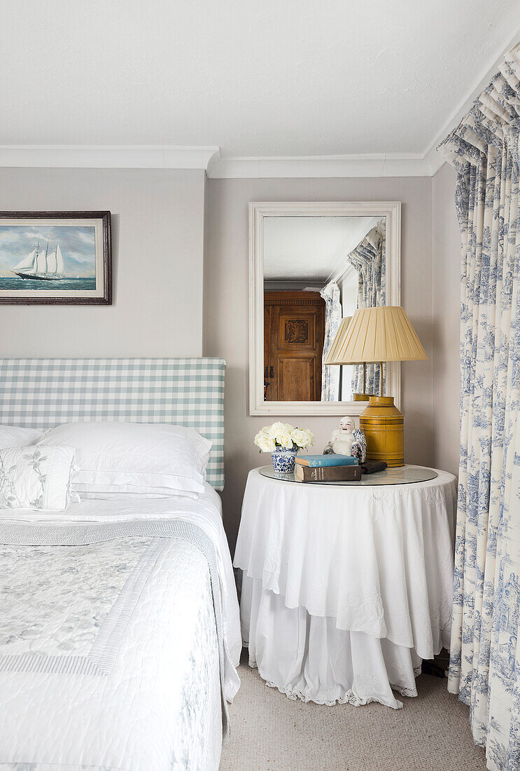 Bedroom with checkered headboard and round side table