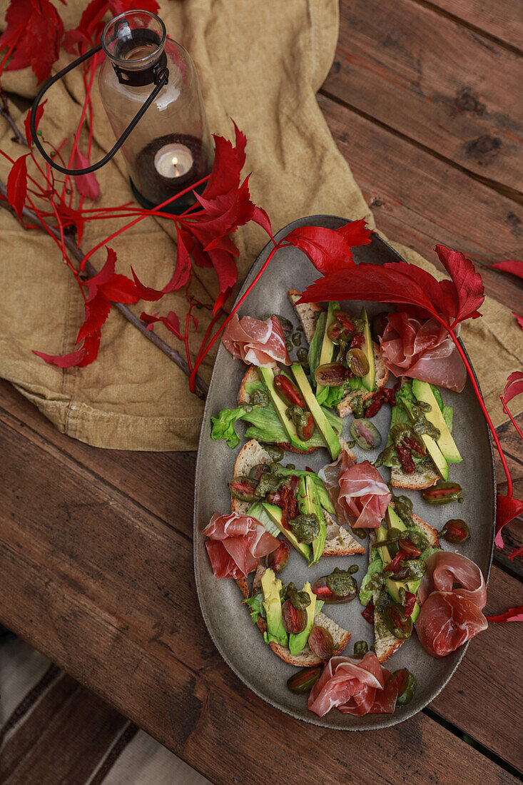 Canapes with Serrano ham and avocado on an autumnal table setting