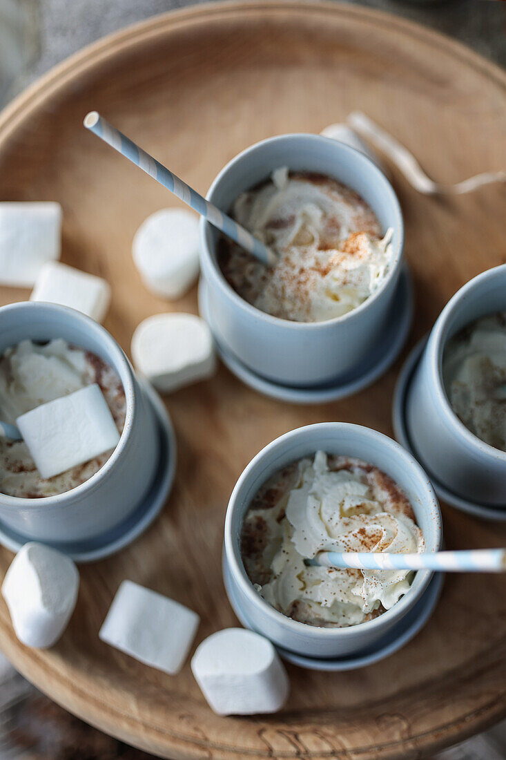 Heiße Schokolade mit Sahne und Marshmallows auf Holztablett