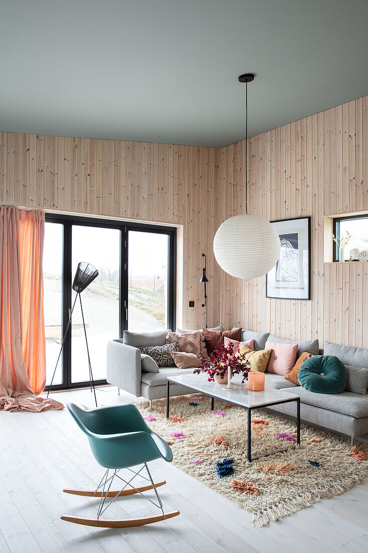 Bright living room with wood panelling and colourful accent cushions