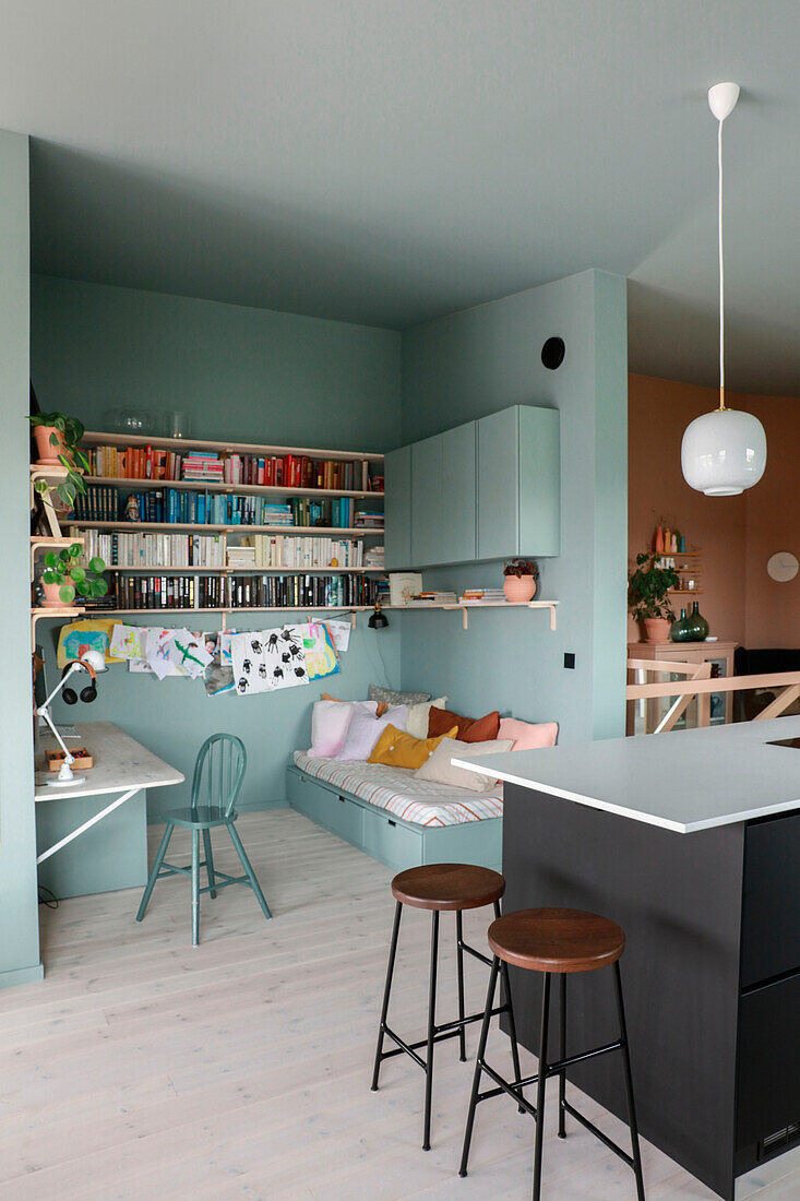 Alcove in pastel blue with desk, cozy seating area and shelves