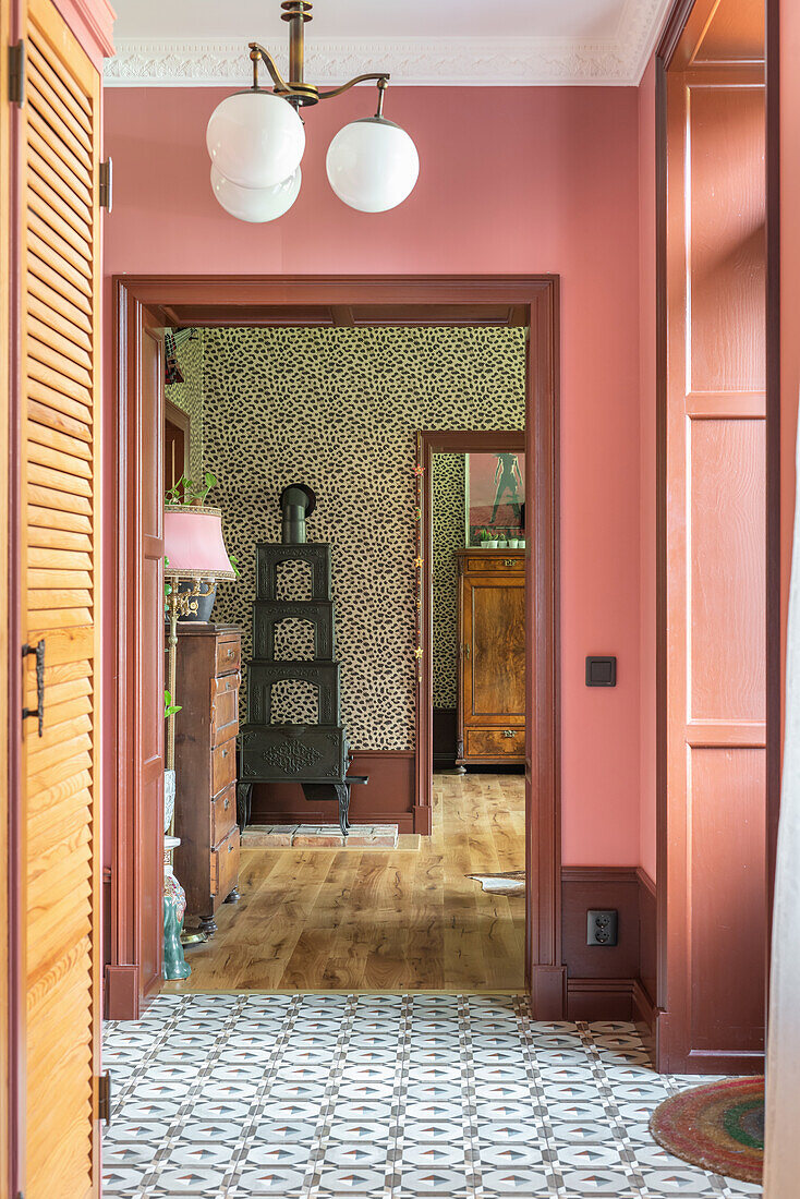 Hallway with pink tones, patterned leopard wallpaper and tiled floor