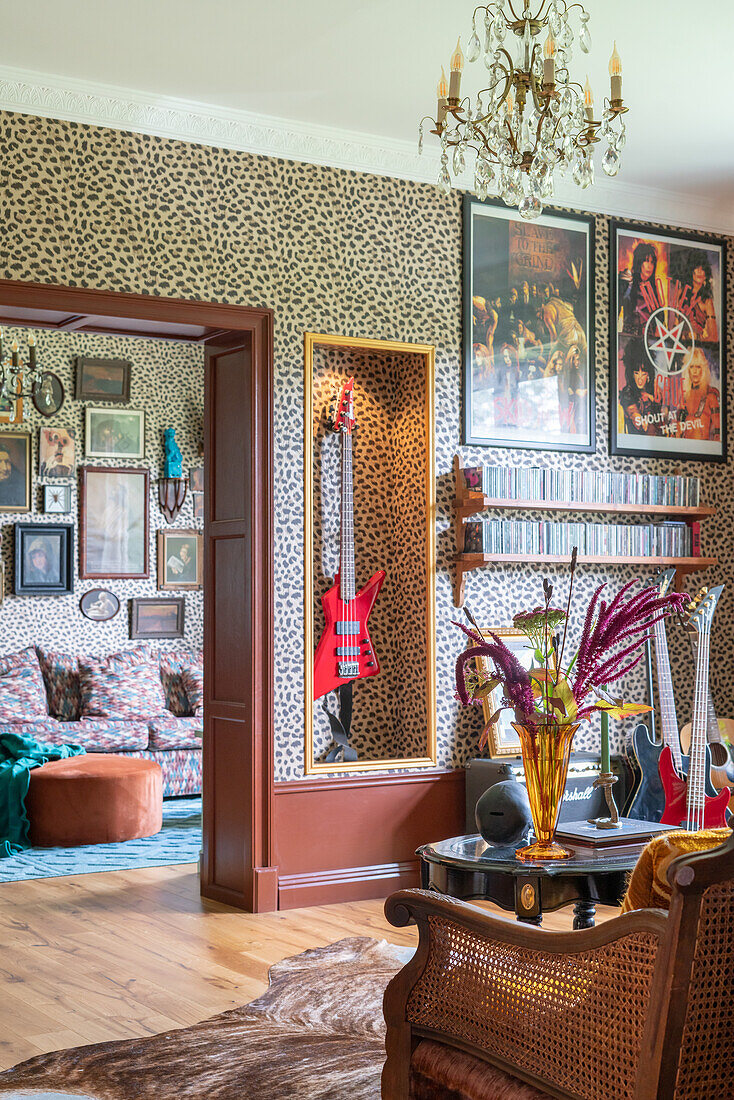 Wohnzimmer mit Leopardenmuster-Tapete, Bandpostern und eklektischer Dekoration