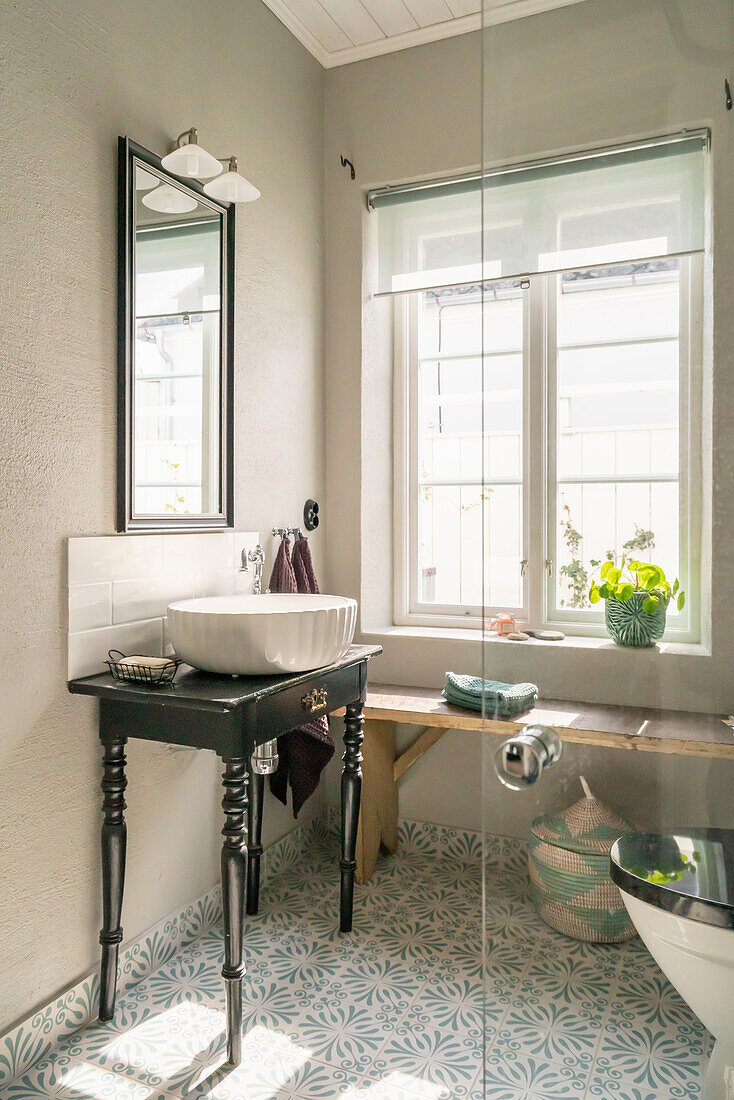 Vintage bathroom with washbasin and patterned floor tiles