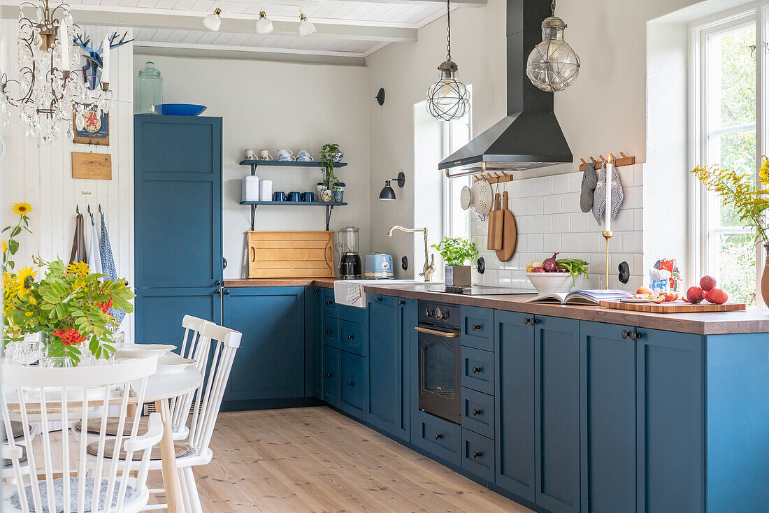 Country kitchen with blue cupboards and white dining area