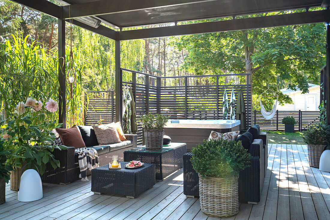 Terrasse mit Loungemöbeln und Pflanzen im Sommer