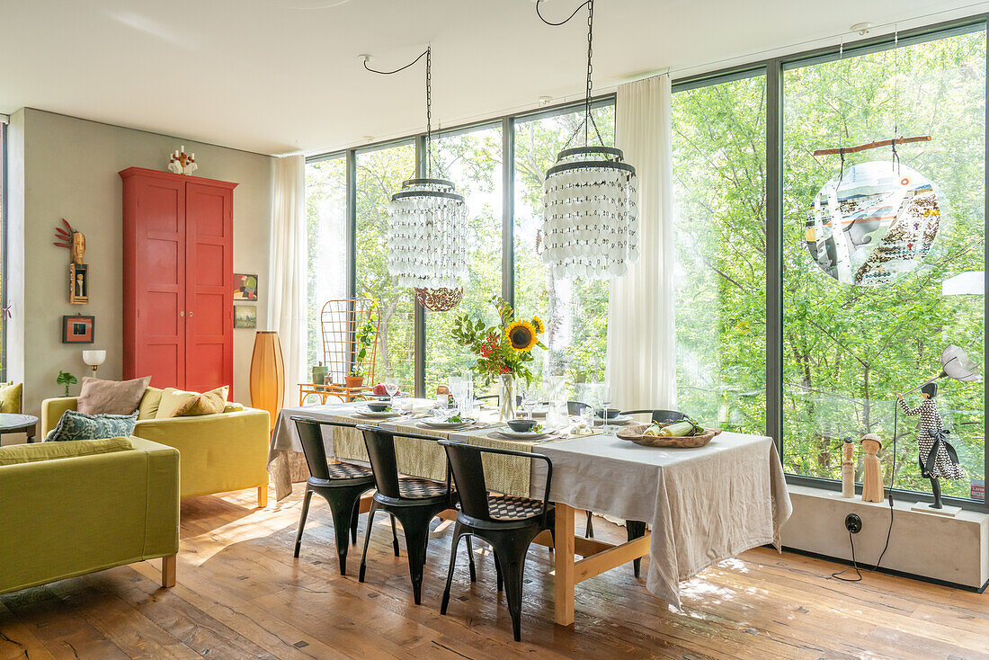 Set dining table, chandelier and view of the greenery