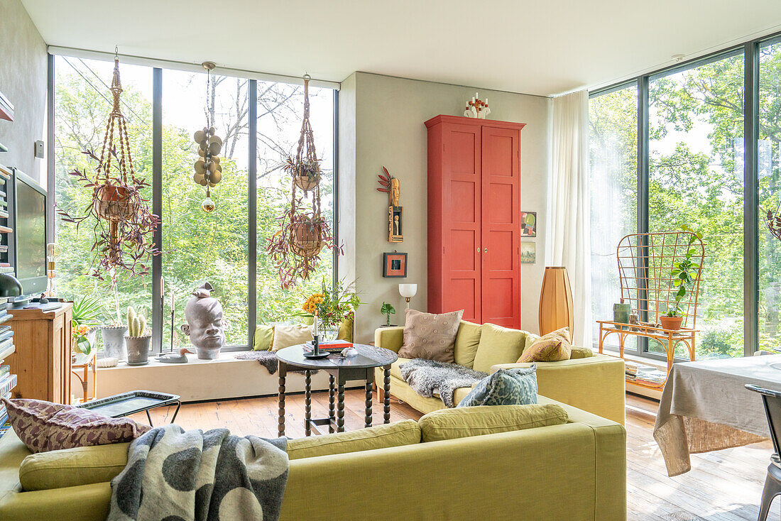 Bright living room with large windows and red cupboard