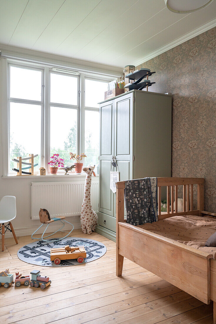 Children's room with wooden bed, toys and retro-style wallpaper