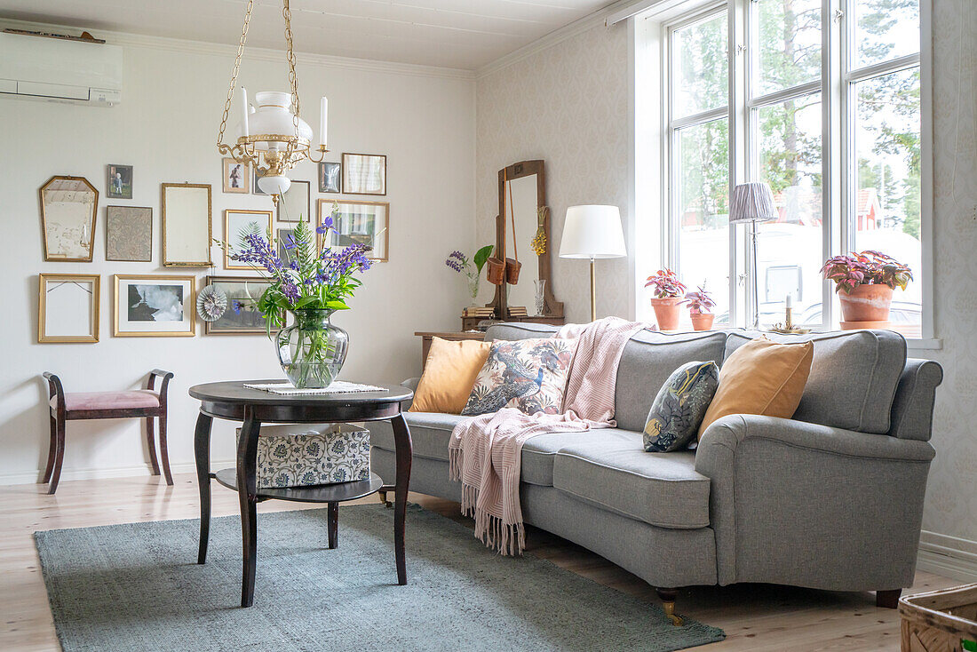 Brightly furnished living room with grey sofa and murals