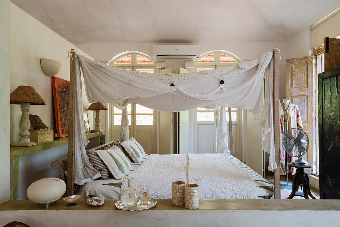 Schlafzimmer im Bohème-Stil mit Himmelbett und Bogenfenstern