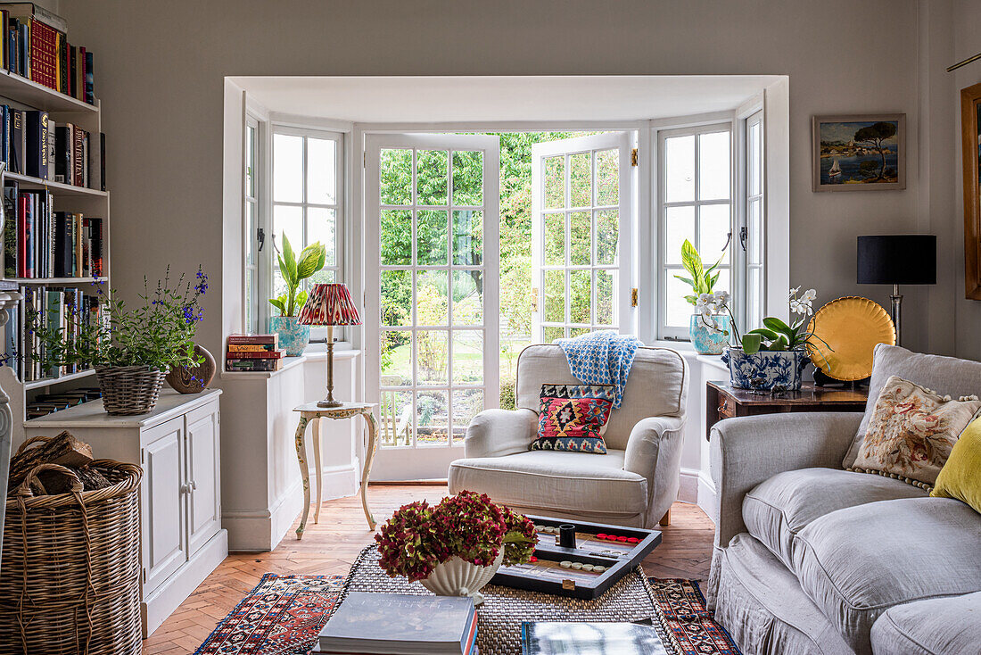 Bright living room with large windows, bookshelf and plants