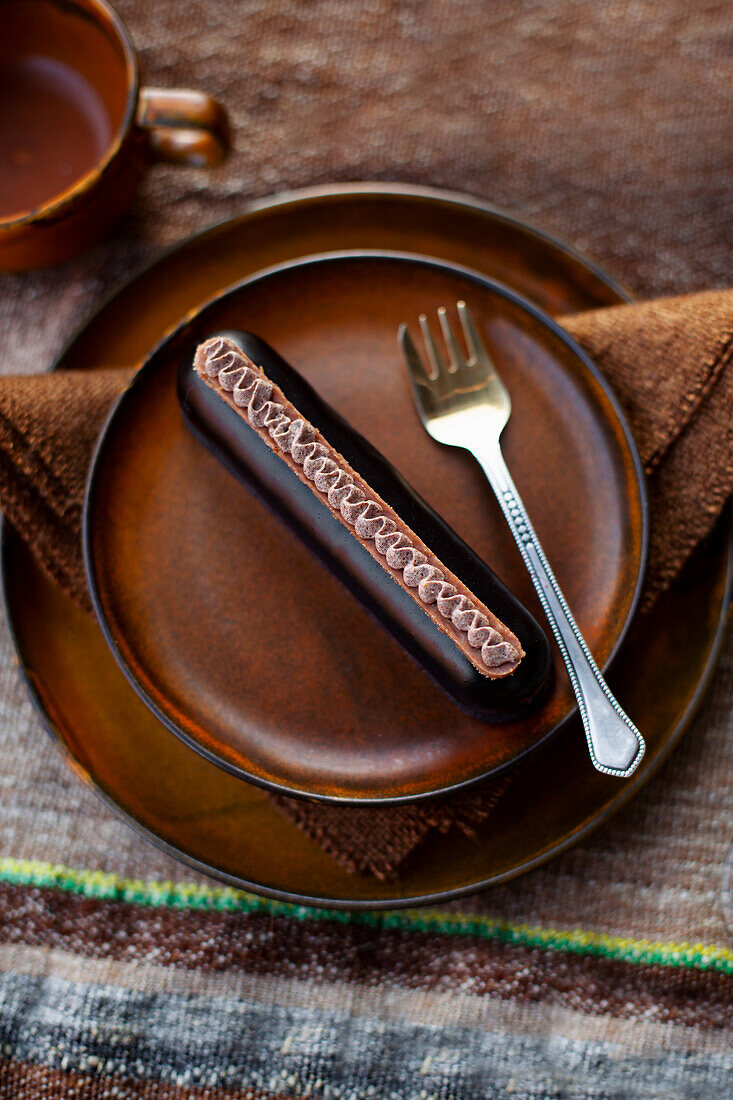 Brown dessert plate with chocolate cake and coffee cup