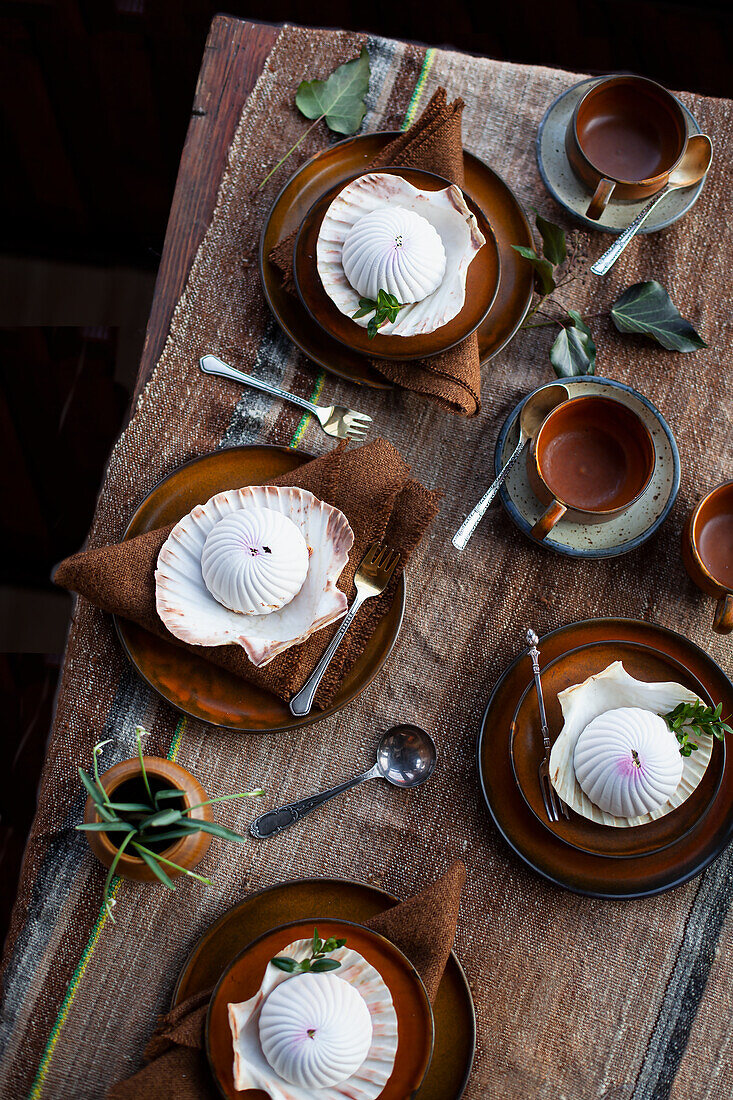 Wooden table setting with ceramic crockery and shell decorations