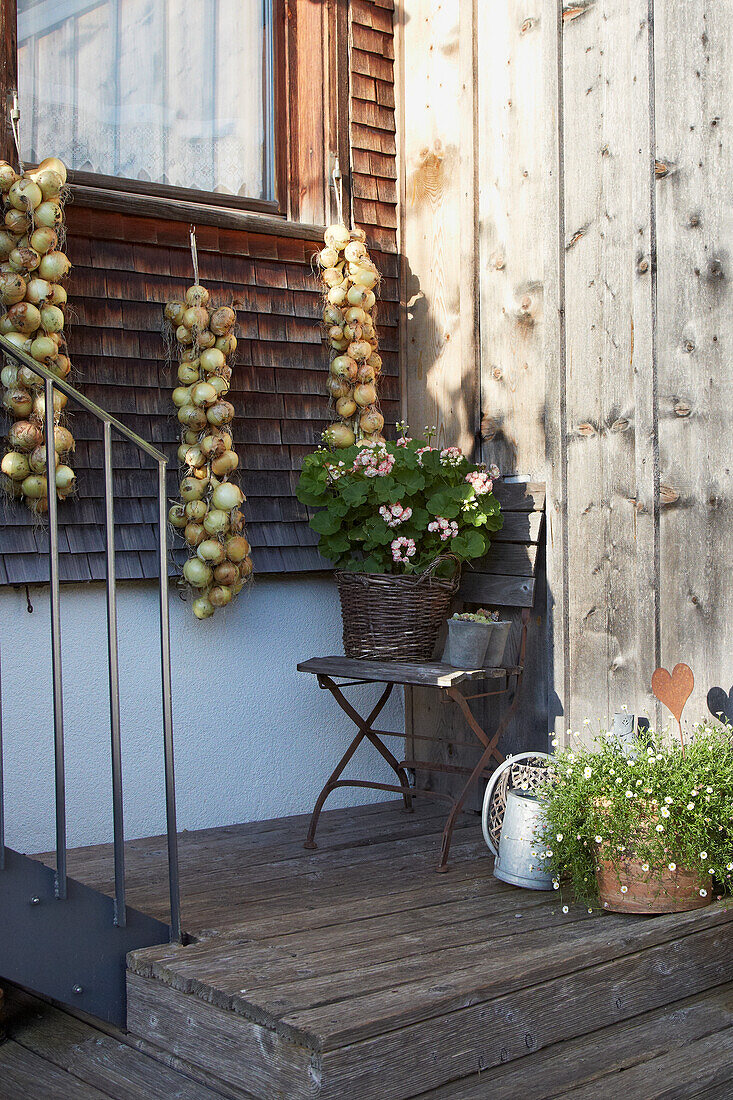 Terrace area with wooden steps, garden chair and decorative plants