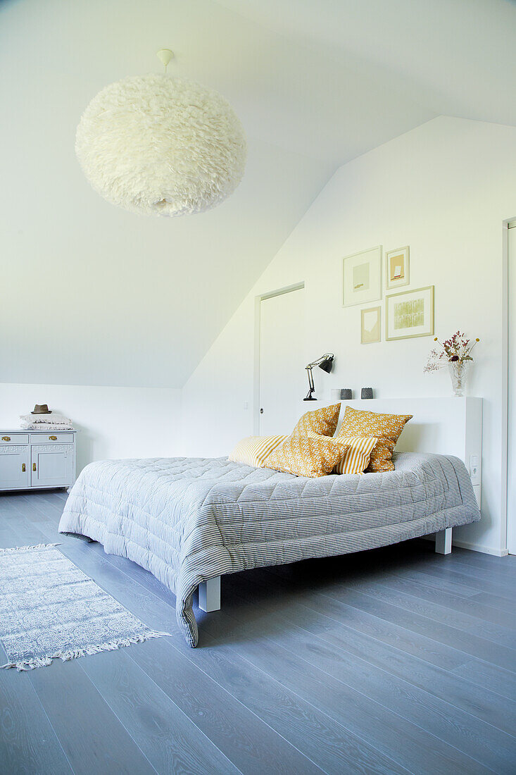 Bright bedroom with grey floor and yellow accent cushions