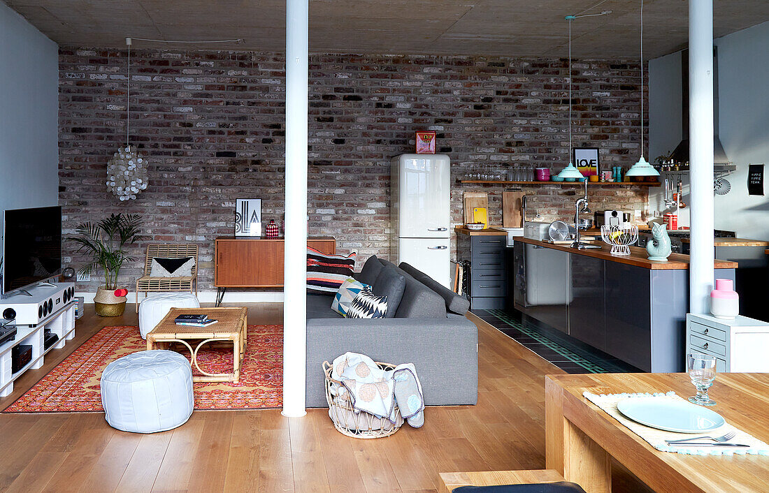 Open-plan living, kitchen and dining area, brick wall