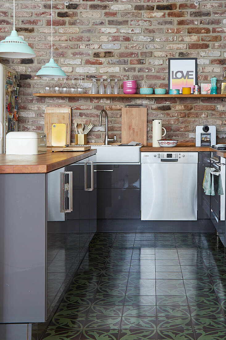 Modern U-shaped kitchen in loft with brick wall