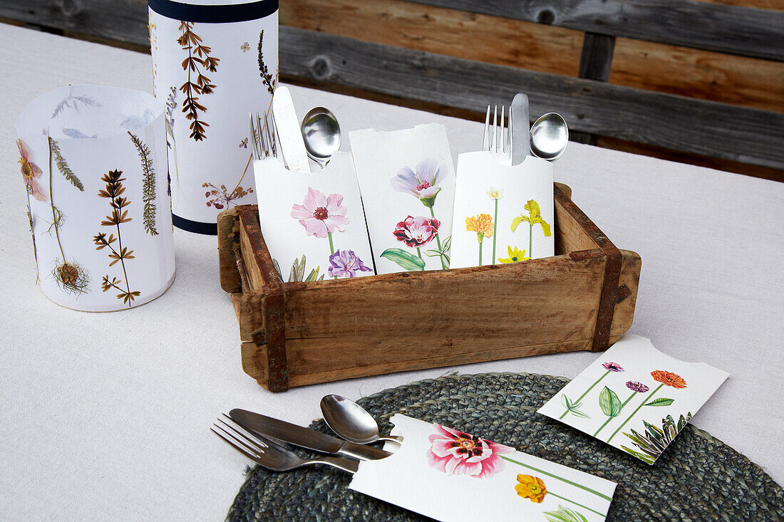 Floral printed cutlery bags in wooden box and on placemat