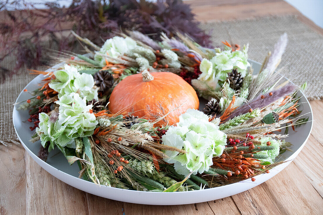 Autumnal table wreath with pumpkin and dried flowers