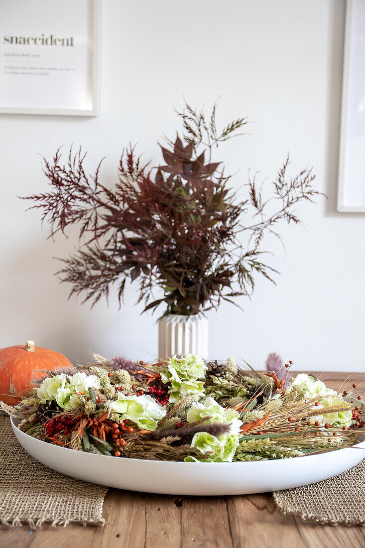 Autumnal table decoration with dried flowers and pumpkin