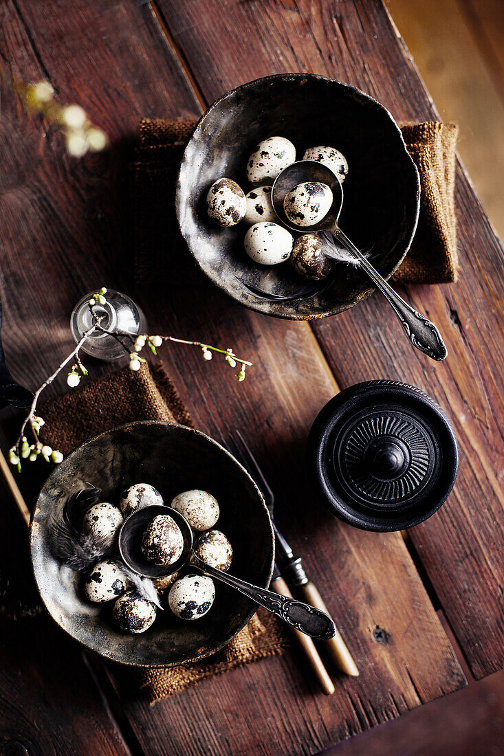 Vintage bowl with quail eggs on a wooden table