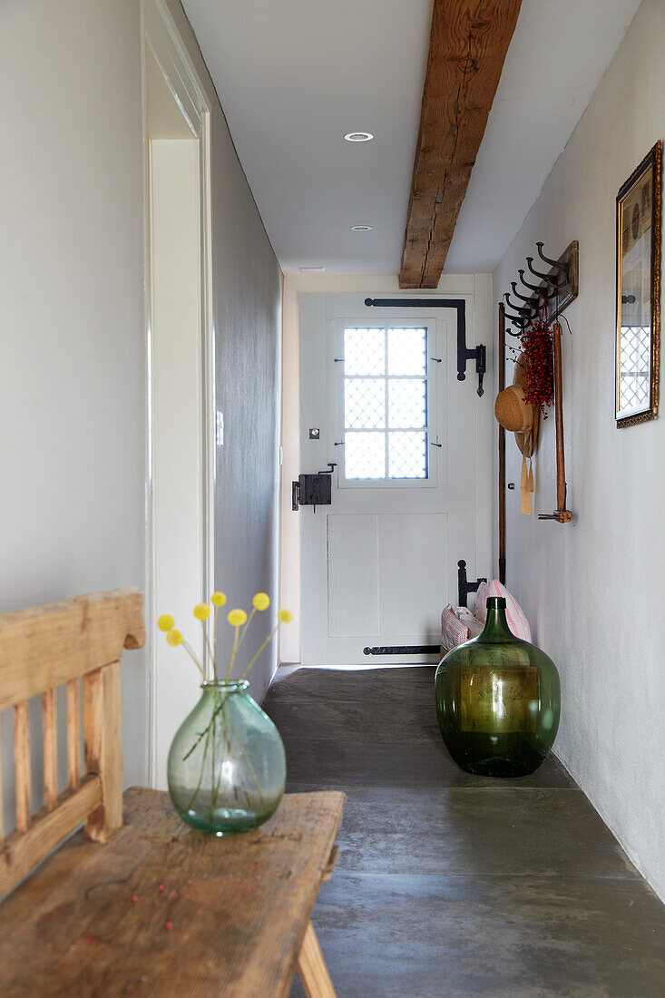 Hallway with rustic wooden bench and green glass vase