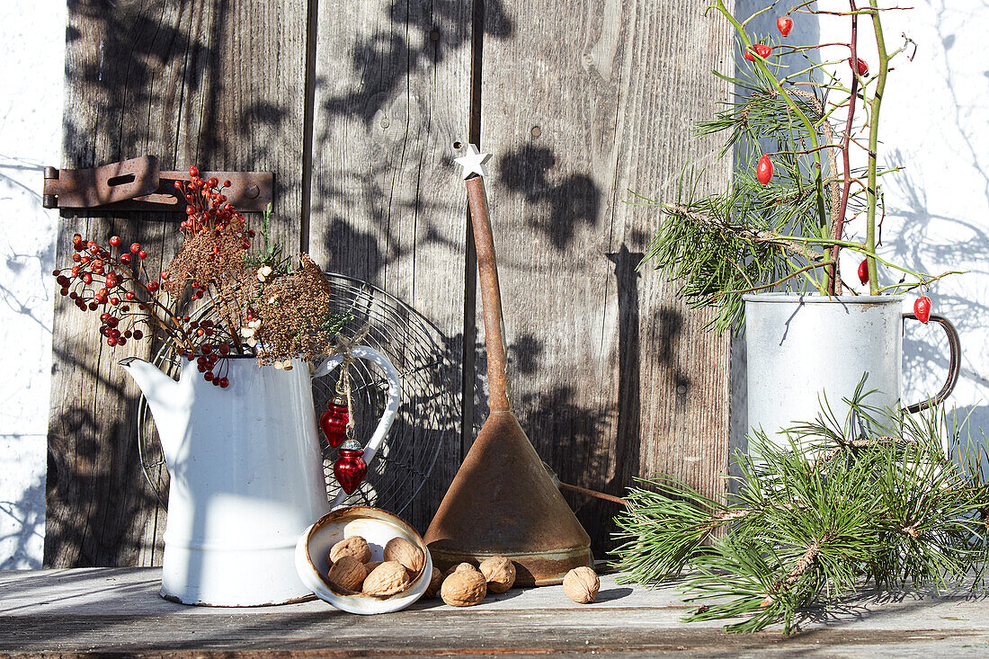 Winter decoration with jugs, berries, twigs and nuts