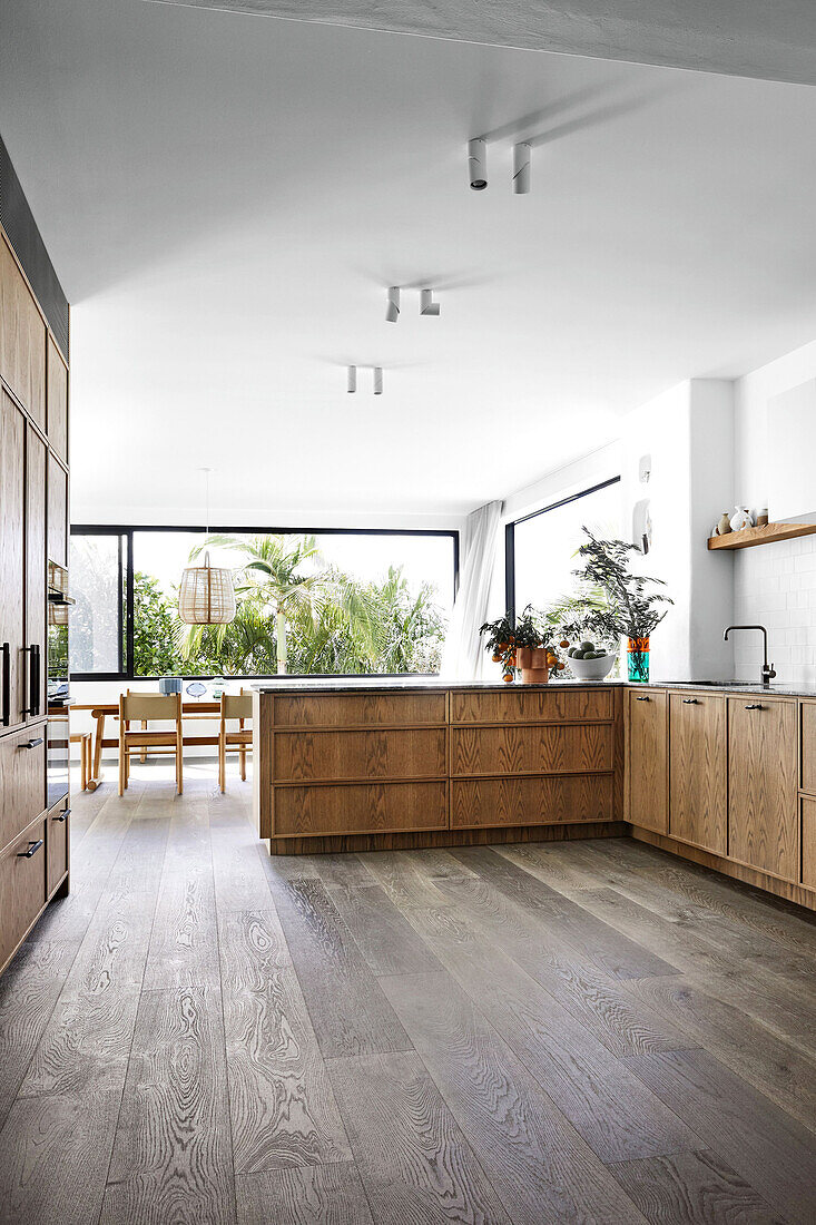 Küchenausstattung mit Holzfronten in hellem offenem Wohnraum