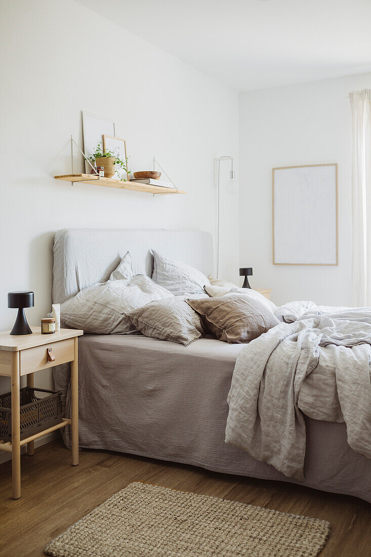 Minimalist bedroom with wall shelf and bed in grey tones