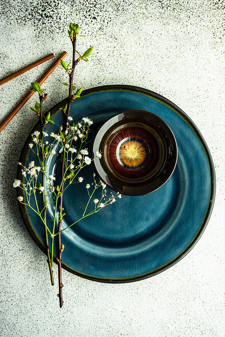 Spring table setting with first leaves and flowers of cherry tree served on the modern concrete table
