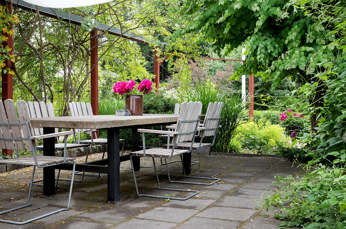 Terrace with garden furniture and flower arrangement in summer