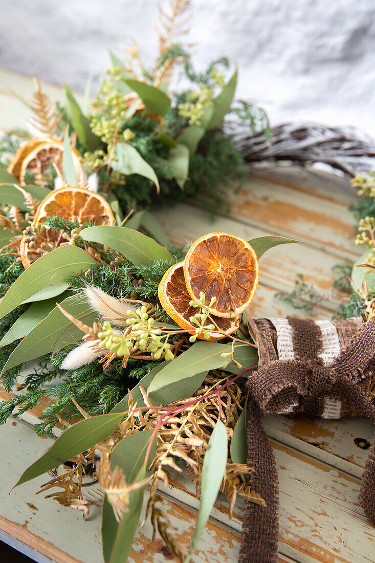 Weihnachtlicher Kranz mit getrockneten Orangenscheiben und Tannenzweigen