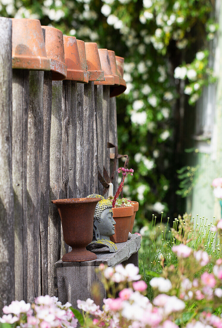 Wooden fence with upside down terracotta pots