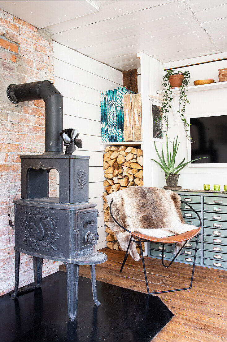 Antique fireplace next to chair with fur and apothecary cabinet