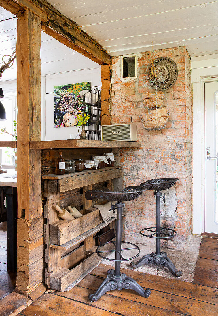 Rustic kitchen counter with bar stools, brick wall