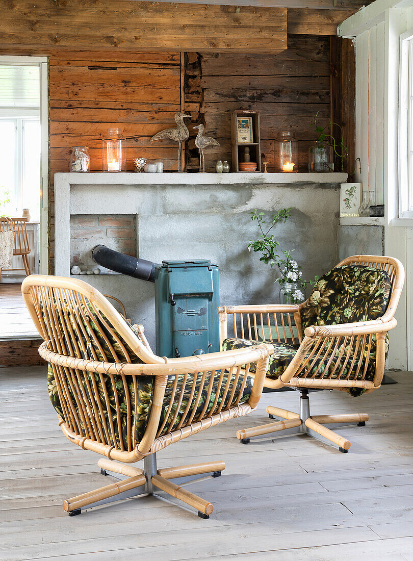 Rattan swivel armchairs in front of a rustic woodstove in a country-style living room
