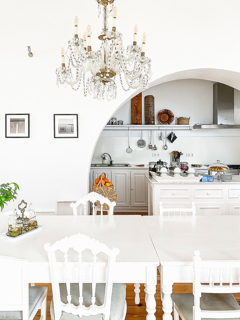 White dining table with chairs in the classically designed dining area with chandelier