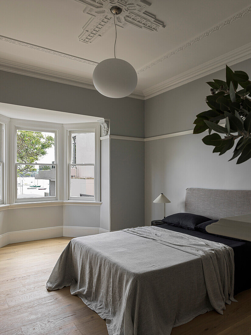 Doppelbett im Schlafzimmer mit grauen Wänden