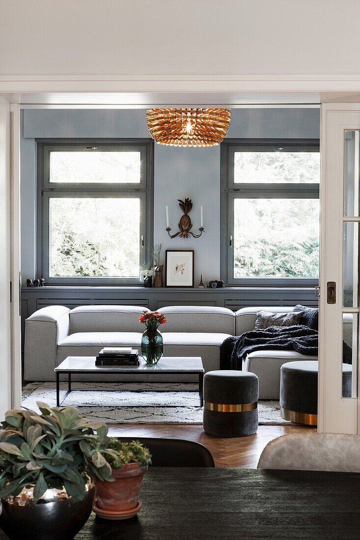 Wohnzimmer mit skandinavischem Design, Holzpendelleuchte und Graunuancen
