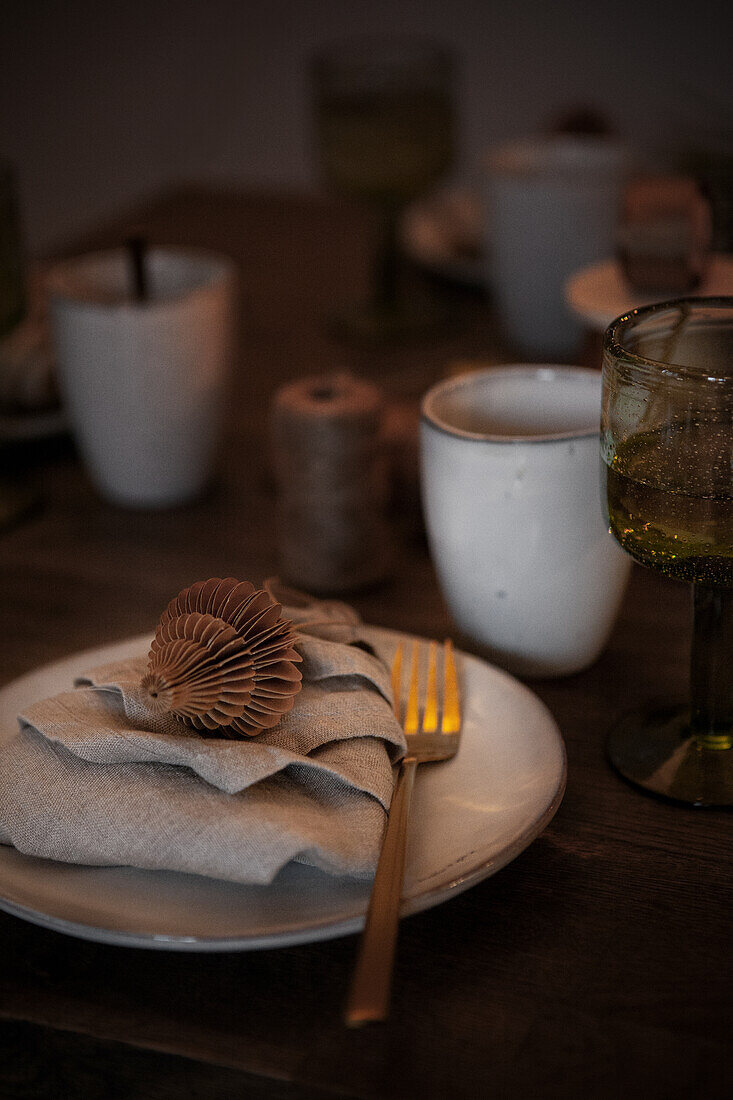 Table setting with folded linen napkin and golden cake fork