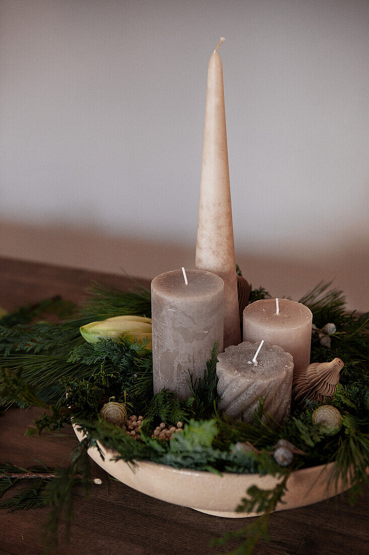 Festive decoration with candles and greens in a bowl