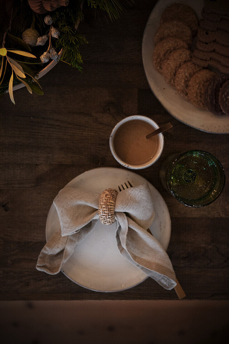 Elegantes Tischgedeck mit Leinenserviette, Kaffee und Keksen