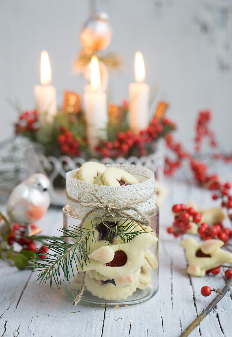 Jam jar with lace ribbon, filled with bird shaped linzer jam cookies