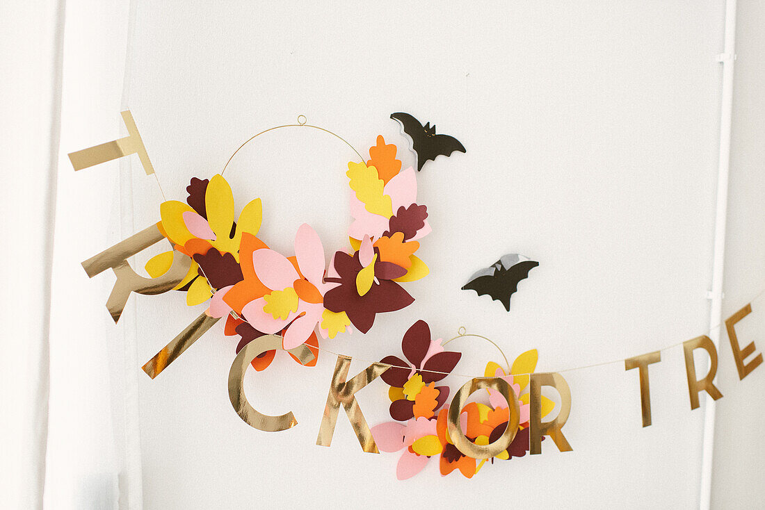Wanddekoration 'Trick or treat' mit Papierblättern und Fledermäusen zu Halloween