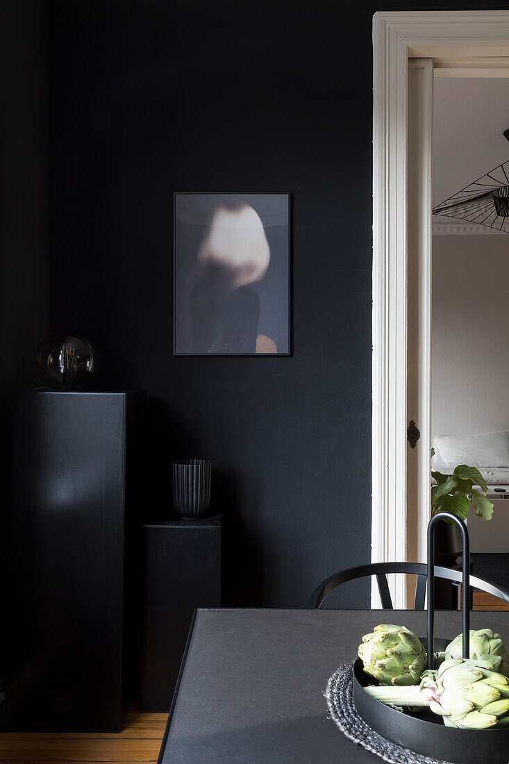 Black table in a dining room with black walls