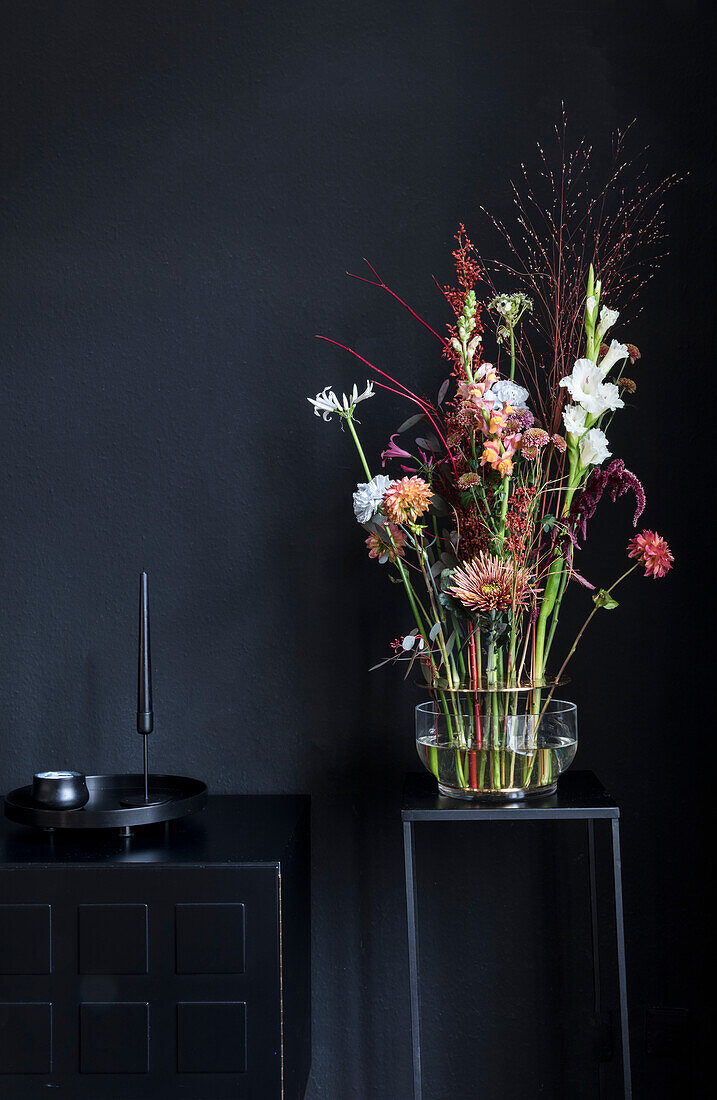 Bouquet on small table in front of black wall