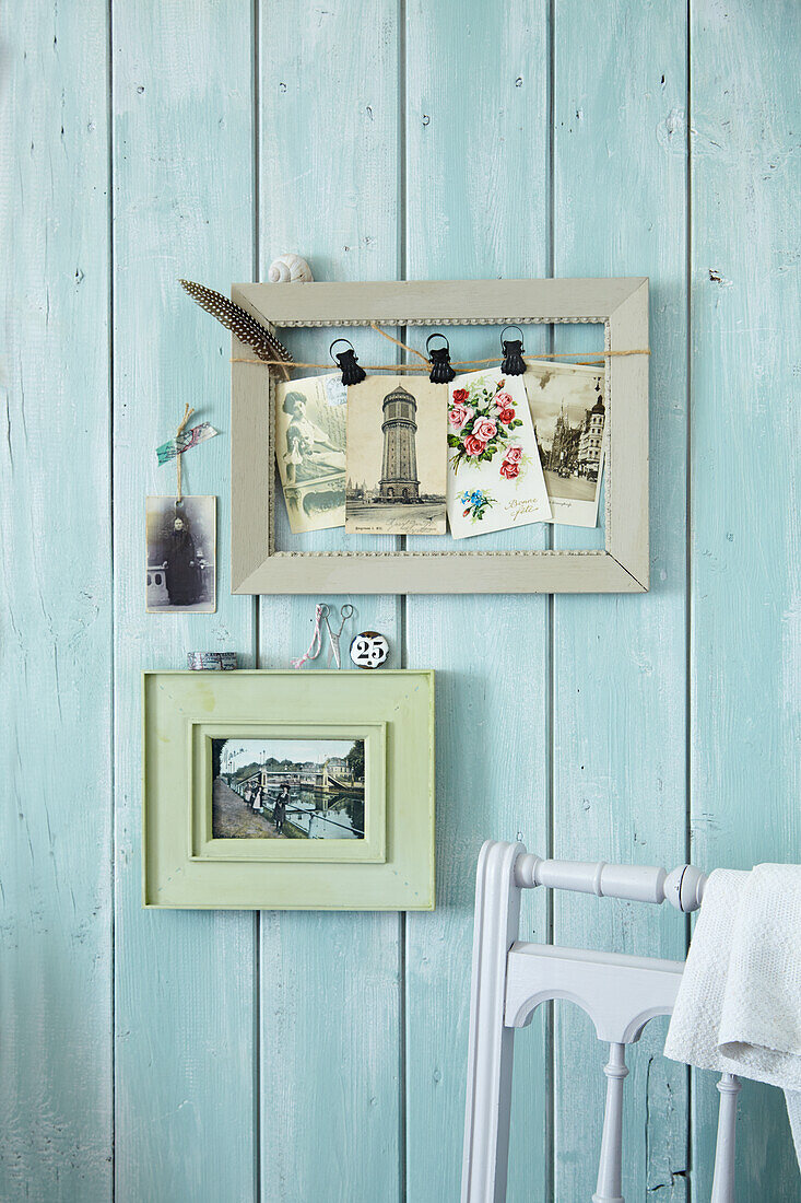 A picture frame as a pinboard with nostalgic postcards hanging on the wall