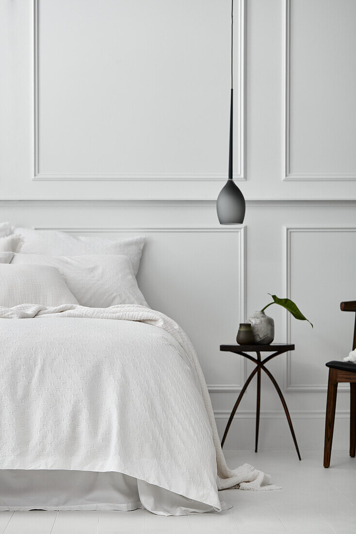 Schlafzimmer im Pariser Stil mit getäfelten Wänden, weißen Böden und weißer Bettwäsche